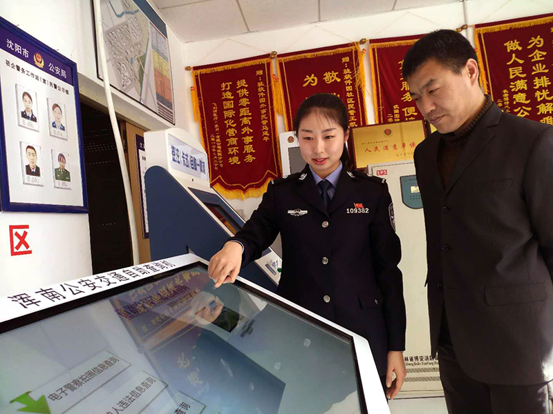 王凱迪(左)演示自助機(jī)操作方法