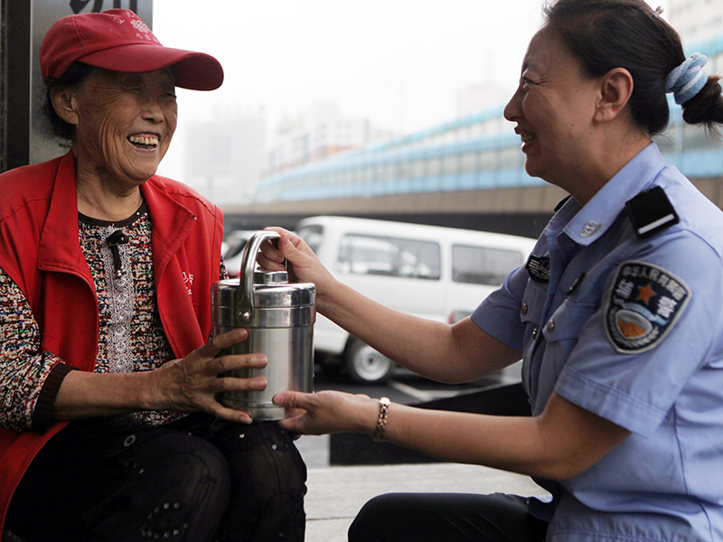 幾年這個愛心團隊的女警們每天堅持為大廳門口賣報攤的金大娘送“愛心午餐”