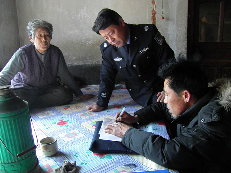 阜蒙縣司法局副局長張彪(中）在受助村民家中走訪