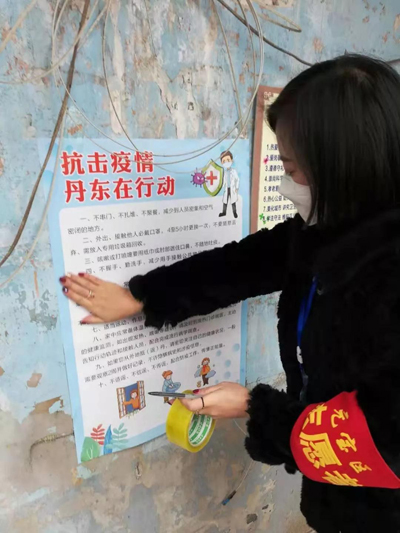 志愿者張貼抗擊疫情海報(bào)