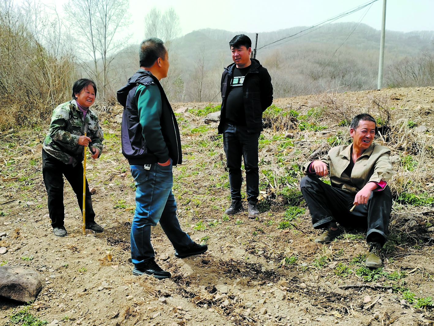 二棚甸子鎮(zhèn)四道嶺子村網(wǎng)格員劉利偉(右二)在地頭調(diào)解矛盾糾紛