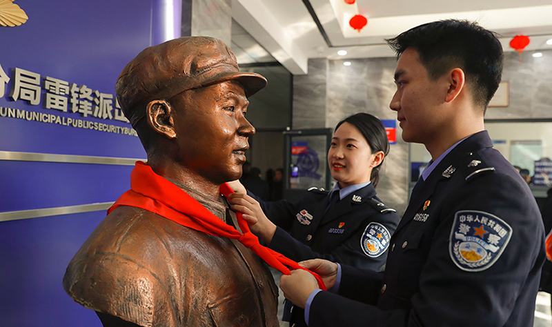 2024年3月5日，撫順市公安局望花分局雷鋒派出所民警白靜（右）和長(zhǎng)沙市公安局雷鋒派出所民警韓政霖（左）共同為雷鋒塑像整理紅領(lǐng)巾。