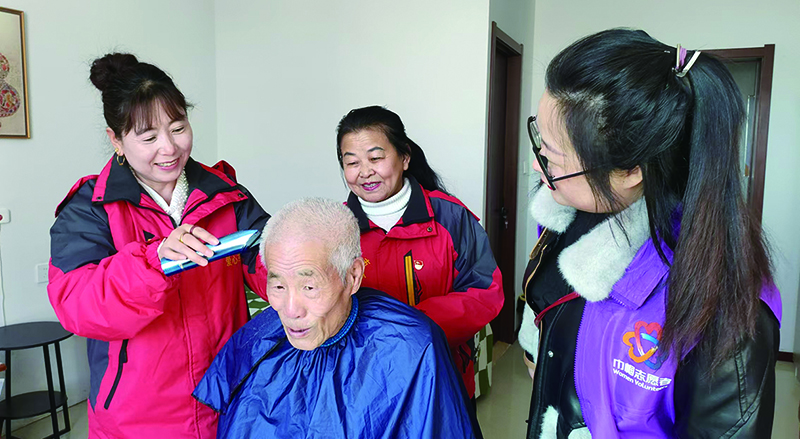 二題圖,專業(yè)社工帶領(lǐng)志愿者們上門為居民義剪