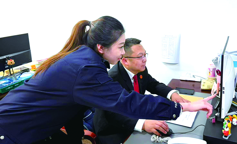 執(zhí)行指揮中心副主任姜浩(右)指導(dǎo)執(zhí)行局干警辦案