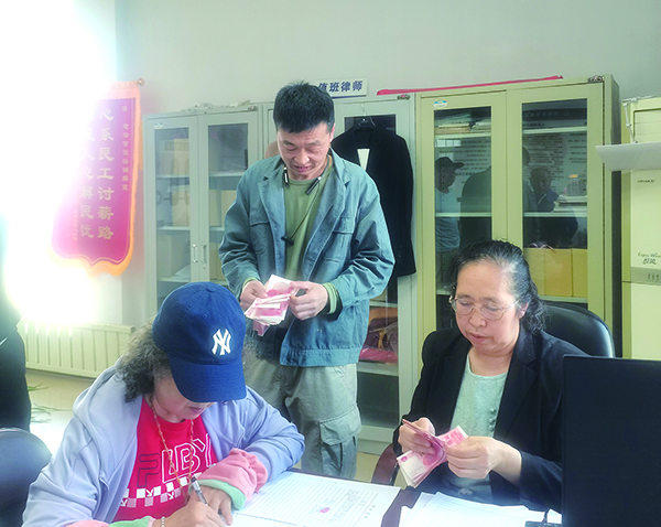 發(fā)放現(xiàn)場(chǎng)，付菊（右一）逐筆核對(duì)勞務(wù)費(fèi)（受訪單位供圖）